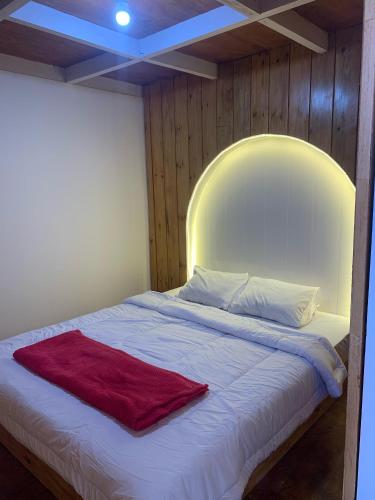 a bed with a red blanket on top of it at Cabin wahyu abadi near prau Mountain type mezzanine in Dieng
