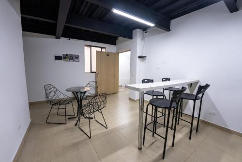 a room with chairs and a table and a counter at Coliving Tonchalá Laureles Habitaciones y Apartamentos Familiares con Cocina cerca del Estadio in Medellín