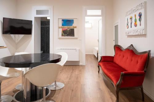 a living room with a red couch and a table at Esperia Maison B&b in Montesarchio