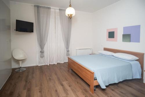 a bedroom with a bed with blue sheets and a television at Esperia Maison B&b in Montesarchio