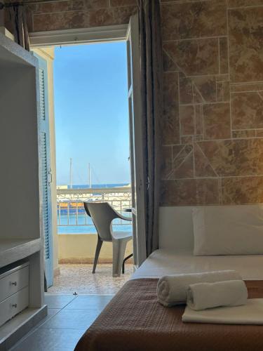 a bedroom with a bed and a view of the ocean at ERRIKA in Ermoupoli