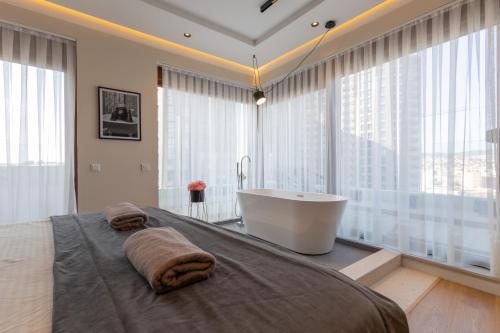 a bathroom with a tub and a large window at Prishtina City Apartments 2 in Pristina