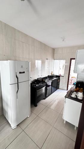 a kitchen with a white refrigerator and a stove at Suíte privativa no centro da capital in Palmas