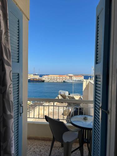 a balcony with a table and a view of the water at ERRIKA in Ermoupoli