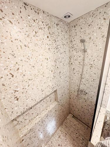 een badkamer met een douche met een betegelde muur bij Terrada Friendly in Bahía Blanca