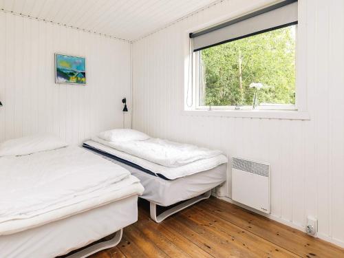 two beds in a room with a window at 8 person holiday home in Ålbæk-By Traum in Ålbæk