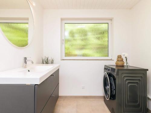 a bathroom with a sink and a washing machine at 8 person holiday home in Ålbæk-By Traum in Ålbæk