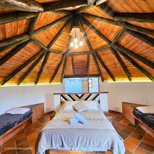 a bedroom with a bed in a wooden ceiling at Ecohotel Buenavista in Villa de Leyva