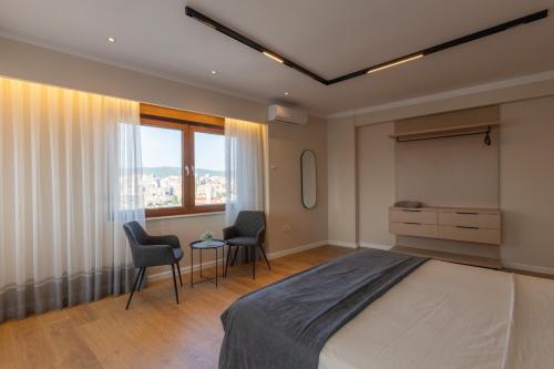 a bedroom with a bed and two chairs and a desk at Prishtina City Apartments 2 in Pristina
