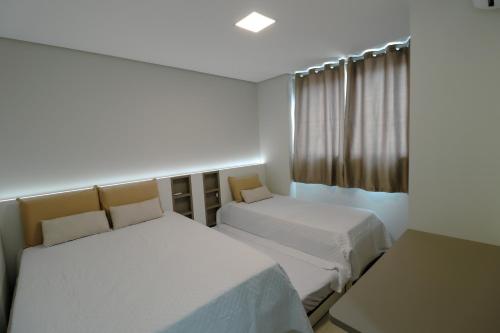 a bedroom with two beds and a window at Apartamento Familiar III Próximo Beto Carrero e Praia in Penha