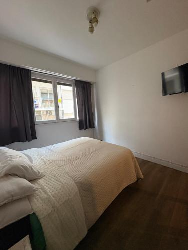 a bedroom with a bed and a window at Departamento frente al casino in Mar del Plata