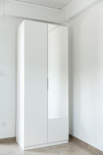 a row of white cabinets in a white room at Appartement des 5 Trésors - piscine et vue panoramique in Case-Pilote