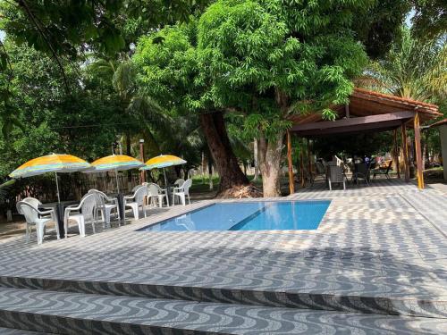 a swimming pool with chairs and umbrellas on a patio at Meu Refúgio - Jer Eco Park in Salvaterra