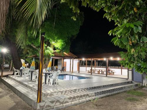 a swimming pool at night with tables and chairs at Meu Refúgio - Jer Eco Park in Salvaterra
