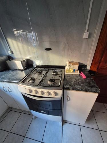 a kitchen with a stove top oven in a kitchen at Amplia Casa Totalmente Equipada in Temuco