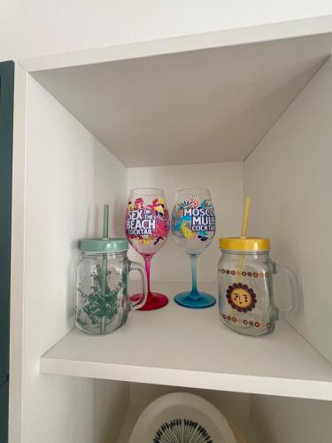 quatre verres à vin et bocaux sur une étagère dans l'établissement T2 cocooning Toulon center-4 people, à Toulon