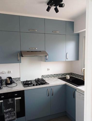 La cuisine est équipée de placards bleus et d'un four avec plaques de cuisson. dans l'établissement T2 vue mer, à Anglet