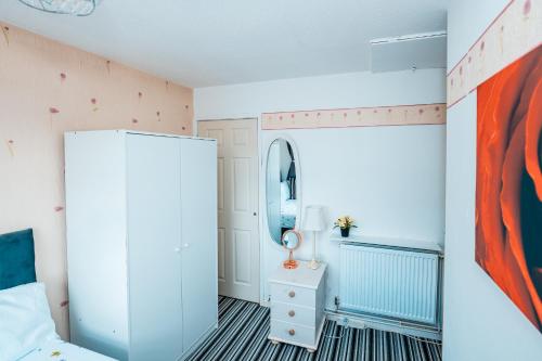 ein Schlafzimmer mit einem Bett und einem Spiegel in der Unterkunft Manchester Retreat for Families Workers Contractors and Event Goers in Manchester