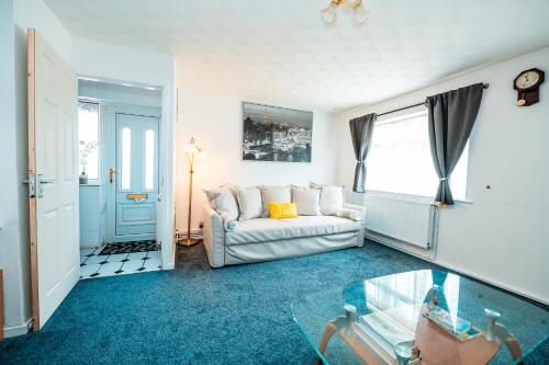ein Wohnzimmer mit einer Couch und einem Glastisch in der Unterkunft Manchester Retreat for Families Workers Contractors and Event Goers in Manchester