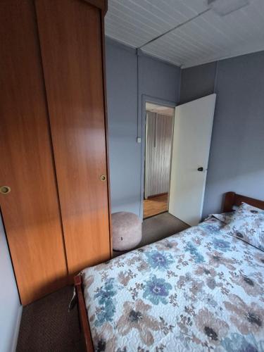 a bedroom with a bed and a cabinet and a mirror at Amplia Casa Totalmente Equipada in Temuco