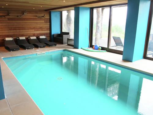 ストゥモンにあるLuxurious Holiday Home in Stoumont with Pool Barの青い壁と窓のある家の中のスイミングプール