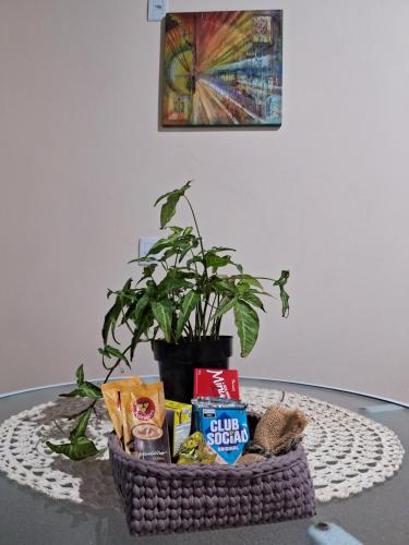 a basket of food on a table with a plant at Pousada Siriemas in Cambara do Sul