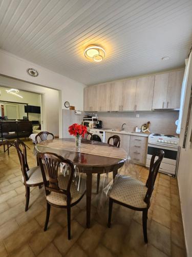 a kitchen with a wooden table and chairs and a dining room at Villa Pelagie Bliss in Nea Kalikratia