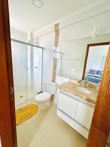 a bathroom with a toilet and a sink at Apê Master 3 dorm espaçoso in São Carlos