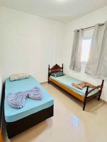 two twin beds in a room with a window at Apê Master 3 dorm espaçoso in São Carlos