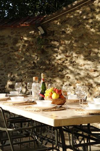 - une table avec des verres à vin et un bol de fruits dans l'établissement LES MAISONS DE GIROUDET La campagne de Paris, à Écrosnes
