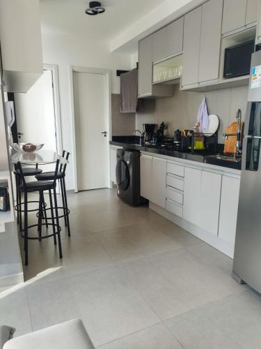 a kitchen with white cabinets and a table and chairs at Quarto privativo Morumbi in São Paulo