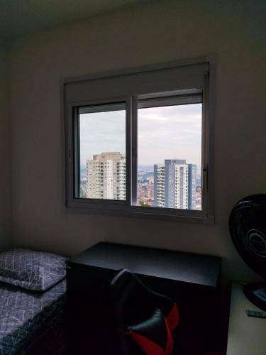 a bedroom with a window with a view of the city at Quarto privativo Morumbi in São Paulo