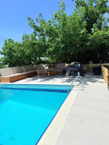 a swimming pool with blue water and trees at Luxury SeaView Villa Pool-Bbq in Neos Voutzas