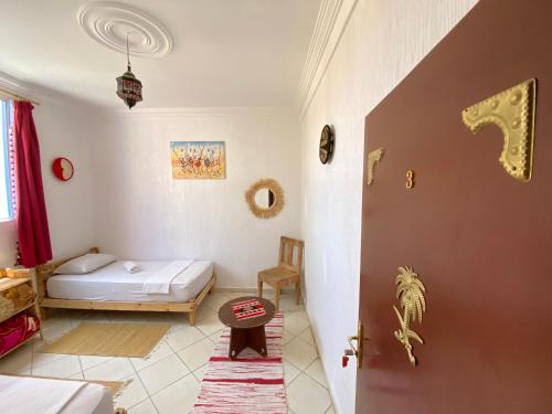 a room with a bedroom with a bed and a door at RED CARPET SURF CAMP - Traditional Moroccan GuestHouse With Stunning Views in Tamraght Ouzdar