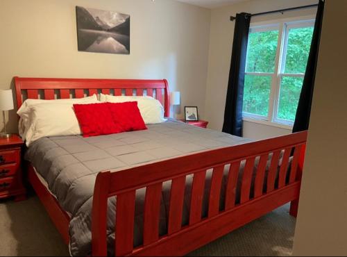 Un dormitorio con una cama con una almohada roja encima. en Golf, pets, hot tub "May the Course Be With You" Ellijay GA, en Ellijay