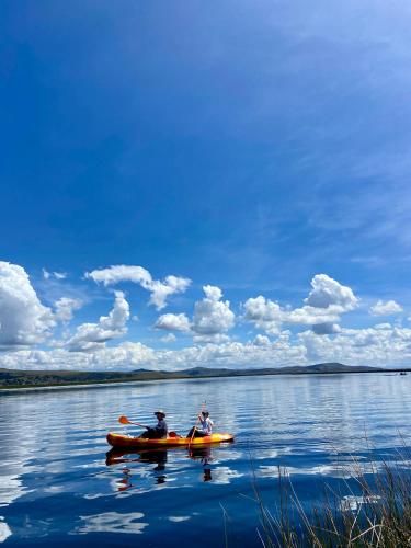 two people in a kayak on a body of water at Uros Titicaca Beluxia in Puno