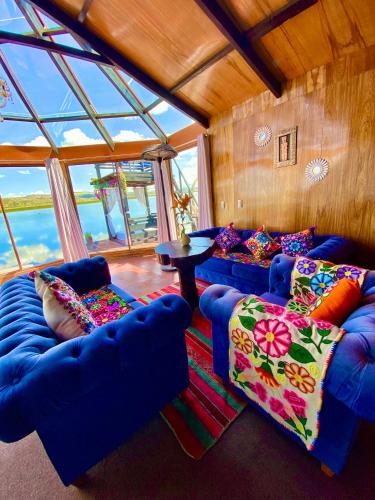 a living room with two blue couches and a table at Uros Titicaca Beluxia in Puno