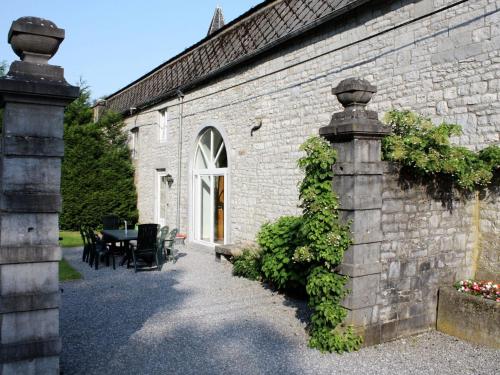 Barvaux-CondrozにあるVintage Castle near Forest in Havelangeのレンガ造りの建物で、テーブルと椅子が隣接しています。