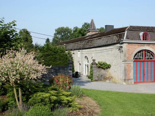 Barvaux-CondrozにあるVintage Castle near Forest in Havelangeの赤いガレージドアのある古いレンガ造りの建物