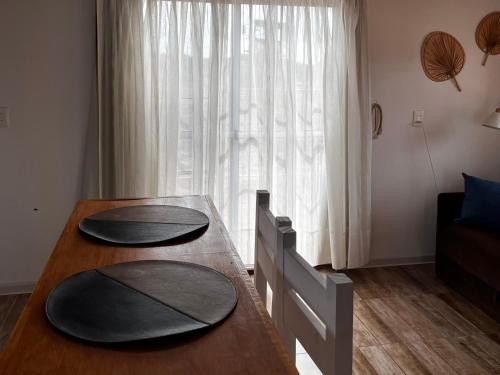 a dining room table with two black plates on it at Rincon de los Michis in Barra del Chuy