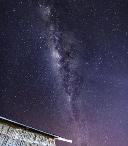 a starry night with a barn and the milky way at Uros Titicaca Beluxia in Puno