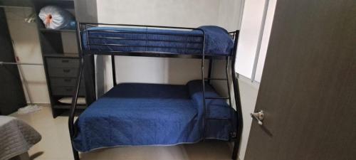 a bedroom with two bunk beds with blue sheets at Tres Palmas Departamentos in Los Mochis