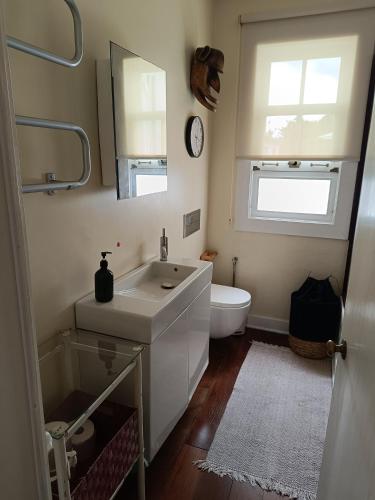 a bathroom with a sink and a toilet and a mirror at Casa dos Narizes in Angra do Heroísmo