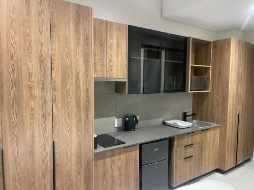 a kitchen with wooden cabinets and a counter top at The Capital Trilogy Menlyn Maine Apartment in Pretoria