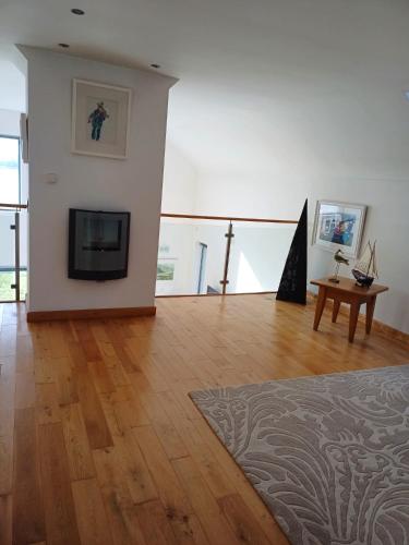 a living room with a television and a wooden floor at The Curlew in Carrigart