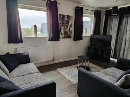 a living room with two couches and a tv at Stylish spacious 2 bed Apt Balcony Nr City Stadium in Manchester