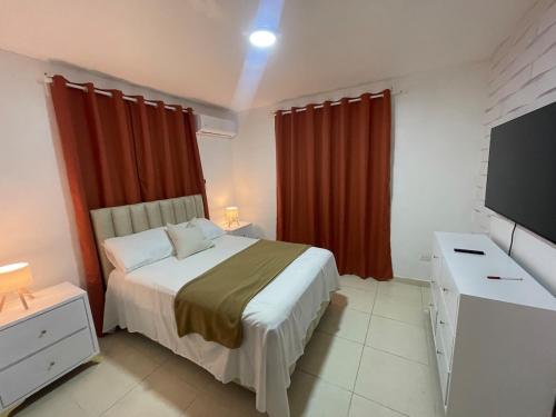 a bedroom with a bed and a flat screen tv at Alojamiento San Isidro in La Grúa