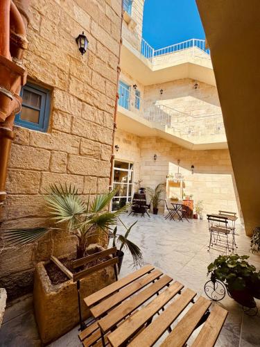 a patio with a wooden bench in a building at Kappella boutique in Malta in Żurrieq