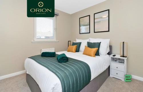 a bedroom with a large bed with green and orange pillows at LUXE Townhouse - LONGER STAYS and REDUCED PRICES Only by Visiting ORION SHORT STAYS, 4 Rooms, Fully Equipped, HOT-TUB, Games Room, EV Power Point, Centrally Located, Newly Renovated and ONLY 5 Mins to STANNERGATE Ports in Dundee
