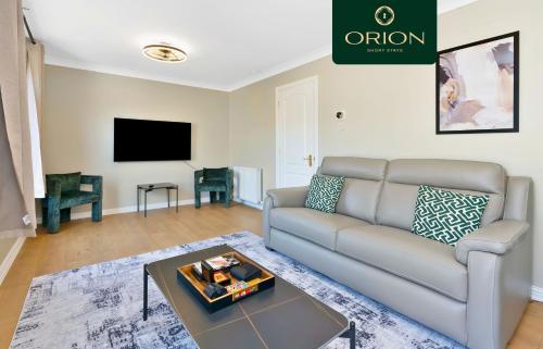 a living room with a couch and a tv at LUXE Townhouse - LONGER STAYS and REDUCED PRICES Only by Visiting ORION SHORT STAYS, 4 Rooms, Fully Equipped, HOT-TUB, Games Room, EV Power Point, Centrally Located, Newly Renovated in Dundee